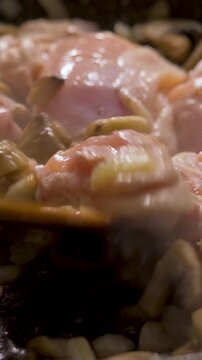 Succulent chicken cooked with mushrooms and onions in pan on stove in kitchen. Classic flavor fusion for homemade meals or cozy culinary experiences