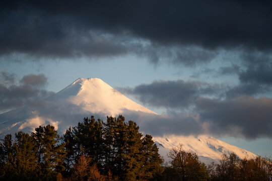 Villarrica Volcano emerging from the gray clouds on a cloudy day in the city of Puc&oacute;n, Chile.