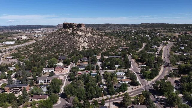 Aerial of residential community and prominent bluff in Castle Rock Colorado in summer with blue sky