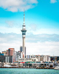 Obraz premium Auckland Sky Tower and waterfront cityscape under a bright blue sky, New Zealand