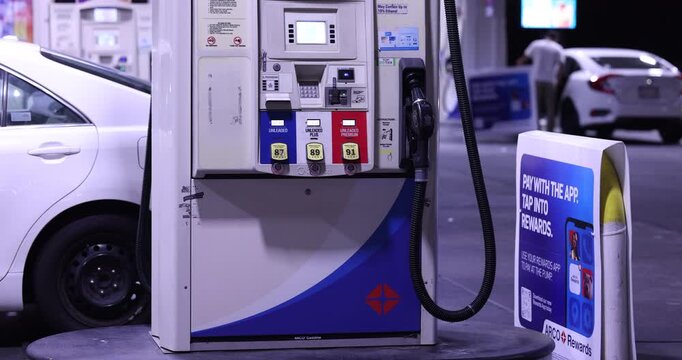 Fullerton, California, USA - September 14, 2026: Vehicles refuel at a gas station with prices surging due to the ongoing war with Iran. 