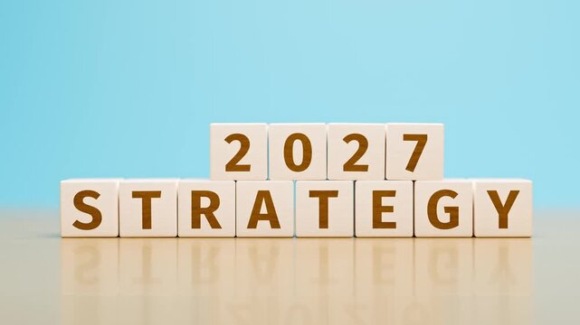 Wooden toy cubes forming the text "2027 STRATEGY". Concept for strategy  or planning for the year 2027 of an organisation or company. Tracking shot