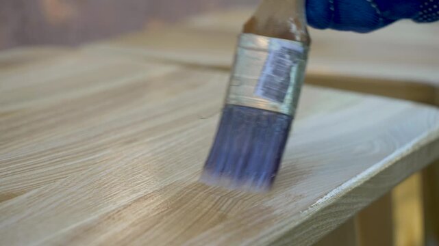 Wooden texture gains refined brilliance as brush applies enamel, forming lasting protective barrier. Coating enhances natural beauty while preventing damage and moisture absorption