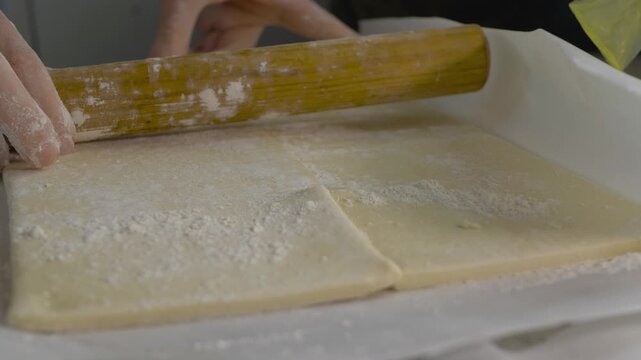 Experienced hands flattening soft dough with careful strokes. Flour evenly distributed for a nonstick process. Preparing for a crispy, flavorful crust. Professional baking pizza