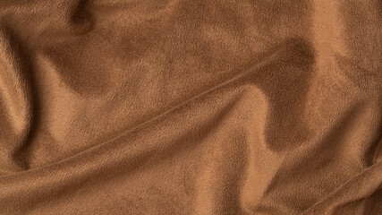 Brown fleece fabric texture background with soft waves and folds, top view, copy space © Anna