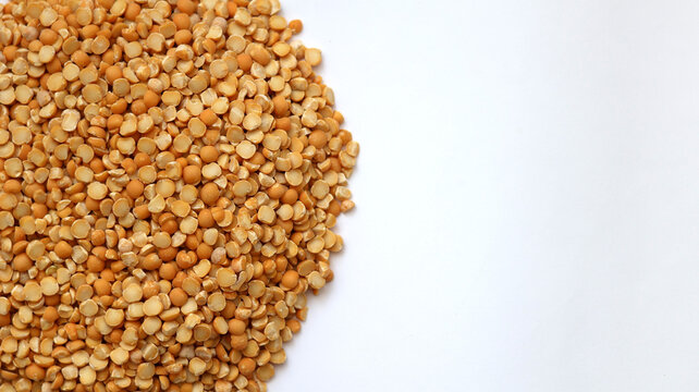 Dried yellow split peas scattered on white background. Healthy Food and Plant Protein. Top view with copy space for text.