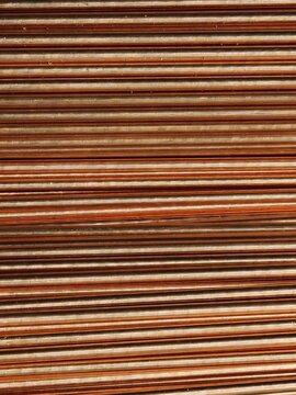 Parallel industrial copper rods texture close-up