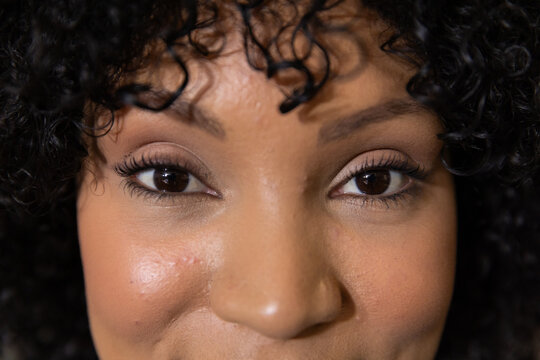 African American woman holding steady pose and looking into camera in studio, showing eyelashes