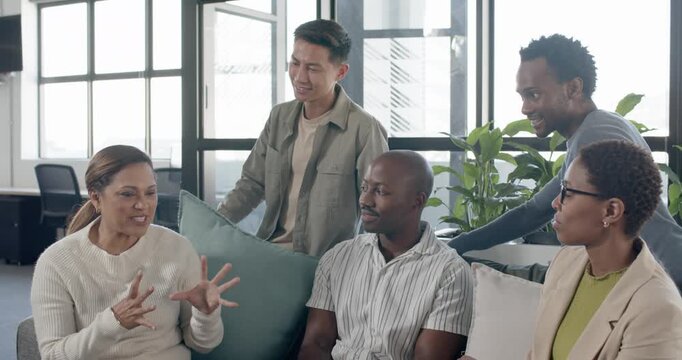 Diverse team watching mature African-American woman on sofa leading, finger-counting aligning team