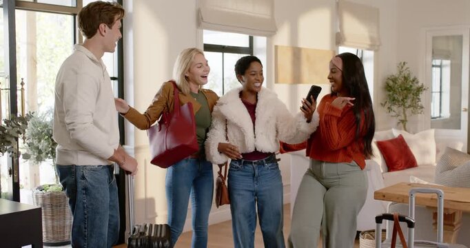 Diverse friends arriving greeting showing phone posing for selfie at entry man holding black case