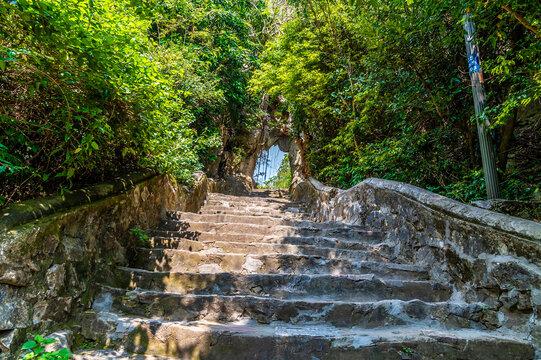 A view up steps leading to an upper level of the Marble Mountains in Da Nang, Vietnam on a bright sunny day