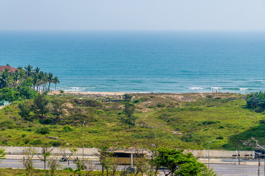 A view from the Marble Mountains towards the beach and sea below in Da Nang, Vietnam on a bright sunny day