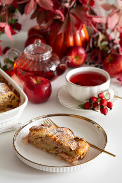 Autumn apple strudel dessert with hot tea and fresh apples on white table