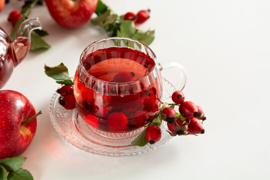 Healthy Rosehip and Apple Tea Brewed in Transparent Teapot and Served in Glass Cup with Fresh Fruits