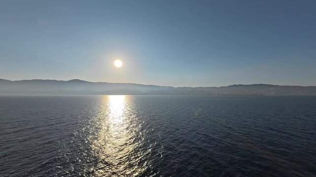 28 April 2026 Italy, Sicily, Strait of Messina - full sunset timelapse passing mountain range and coastline of Zona Falcata Maregrosso Faro Lanterna di San Raineri