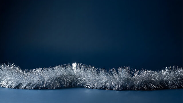 Silver tinsel sparkling across a dark blue Christmas background
