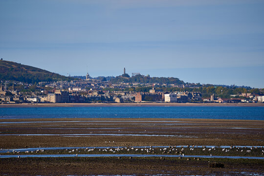 Edinburgh skyline and Calton Hill across Firth of Forth at low tide