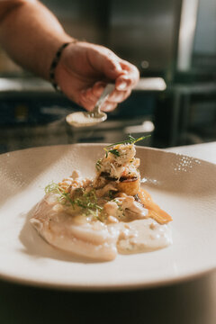 Chef adds finishing touches to a gourmet crab and pasta dish
