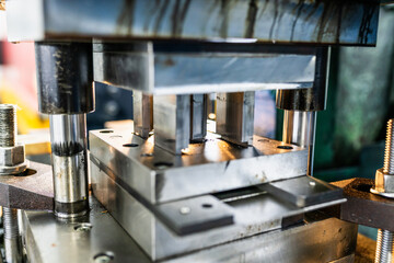 Plakat Industrial blanking die in operation on mechanical press. Metal stamping tooling during factory production