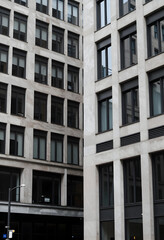 Fototapeta premium Urban development and corporate architecture, modern office building facade with stone cladding and glass windows in a dense city business district