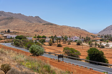 Obraz premium Winding road leading to Vega de Rio Palmas village between mountains, Fuerteventura, Canary Islands, Spain.