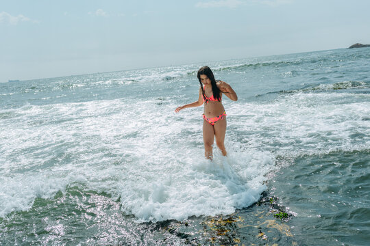 Child Standing in Ocean Waves During Summer Beach Vacation