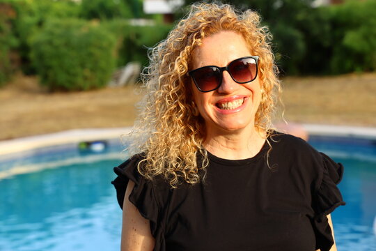 Smiling Woman Enjoying a Sunny Summer Day by the Pool