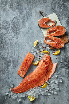 Raw salmon fillets and steaks with lemon and ice