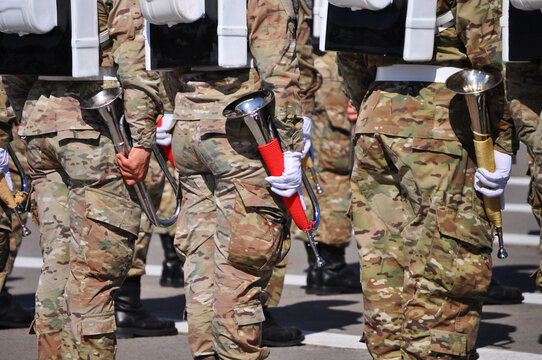 Uniformed soldiers lined up holding their bugles