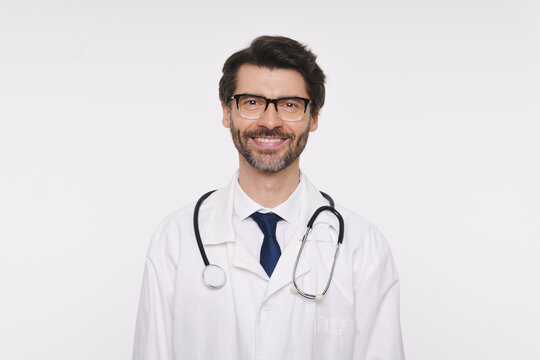 Portrait of doctor, general practitioner, physician, medical professional wearing white uniform coat and stethoscope, posing looking at camera and smiling isolated on white studio background