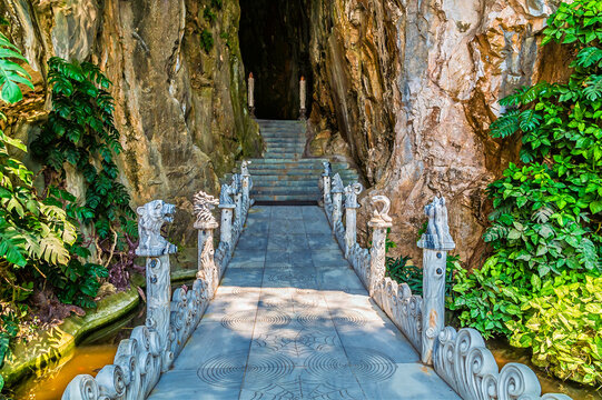 A view towards the entrance bridge to Hell Cave inside the Marble Mountains near Da Nang, Vietnam on a bright sunny day
