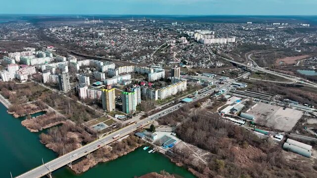 Riverside residential district with road bridge and railway corridor from a drone. Urban planning, housing density, transport connectivity and riverside real estate