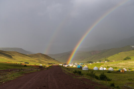 Double Rainbow Over Traditional Yurt Settlement in Rolling Hills Kyrgyzstan