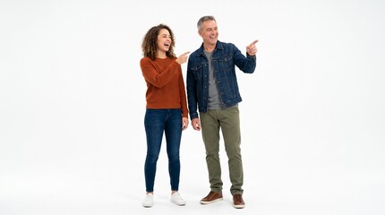 Obraz premium Cheerful man and woman pointing away while standing isolated on white background