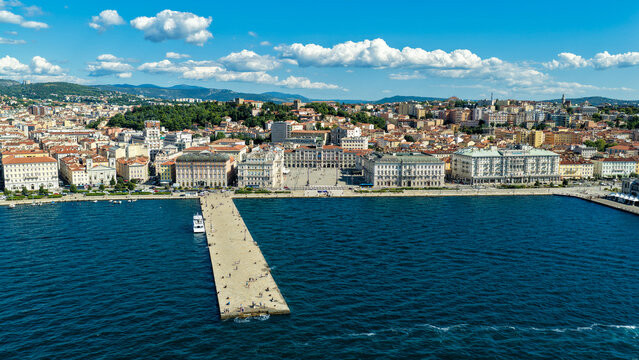 Aerial view of Piazza Unita d'Italia and the Molo Audace pier extending into the Adriatic Sea, surrounded by historic architecture and urban cityscape in Trieste, Friuli-Venezia Giulia, Italy.