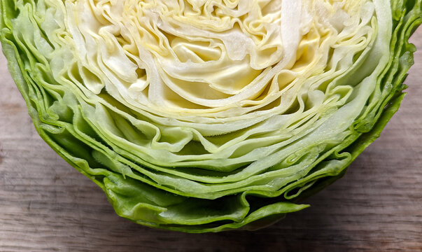 Fresh green cabbage cut in half macro close up texture background on wooden table raw organic vegetable head healthy eating dietary nutrition agriculture produce food cooking ingredient concept