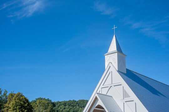 White church steeple with cross against blue sky