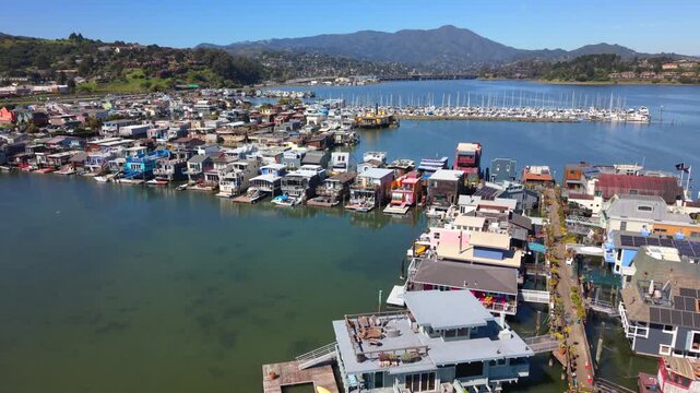Aerial view of the colorful Sausalito Houseboats floating on the calm waters of the marina with hills in the background in Sausalito, California, United States.