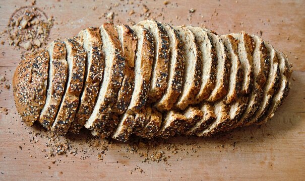 Mainz, Rhineland Palatinate, Germany: Sliced multigrain bread with seeds and crispy crust on wooden cutting board.