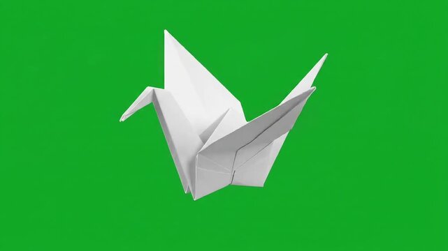 Origami paper crane flying on green screen background