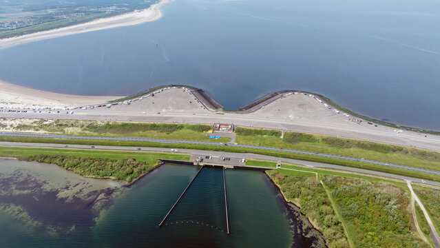 Aerial view of Brouwersdam, a major coastal engineering project separating the North Sea from the Grevelingen lake, with sandy beaches and roads in Ouddorp, Zuid-Holland, Netherlands.