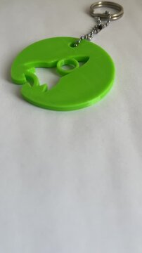 Green 3D printed keychain with rocket cutout design innovation