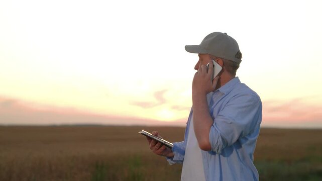 Farmer talking smartphone wheat field, male farmer worker phone sunset, hand holding digital tablet, business success industry, man in cap using tablet in barley field at dusk, precision agriculture