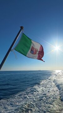 Italian flag flying from a boat over the open sea