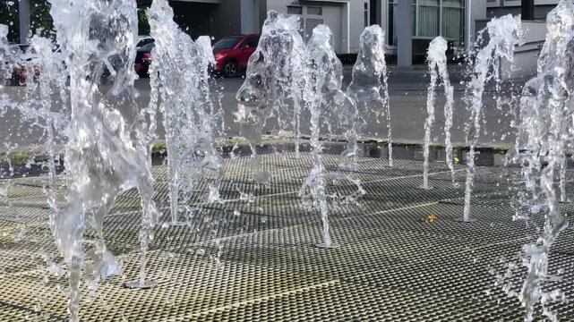 The vertical jets of a city fountain refresh the air on a hot summer day