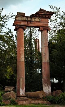 Wiesbaden, Hesse, Germany: Historic sandstone columns and architectural ruins surrounded by dense greenery in urban park.