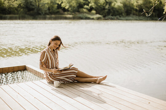 Serene moments by the lake with a book and a warm drink