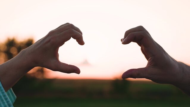woman man showing heart with hands, lovers couple happy man woman traveler sunset, female male freedom, people outdoors nature, affectionate couple silhouette, sentimental couple photography, timeless