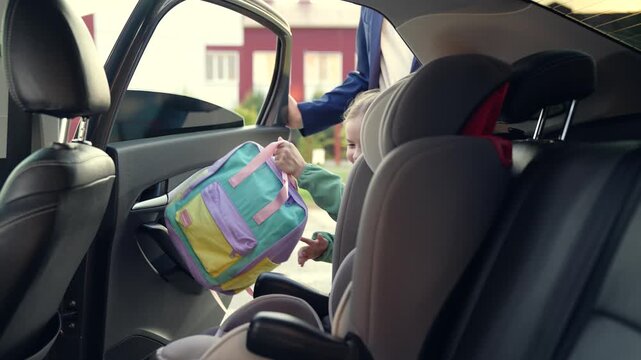 child seat car. father man puts girl daughter child seat car. happy family. schoolboy child seat. happy child car seat. childhood trip with dad. road traffic. road safety rules. girl with school