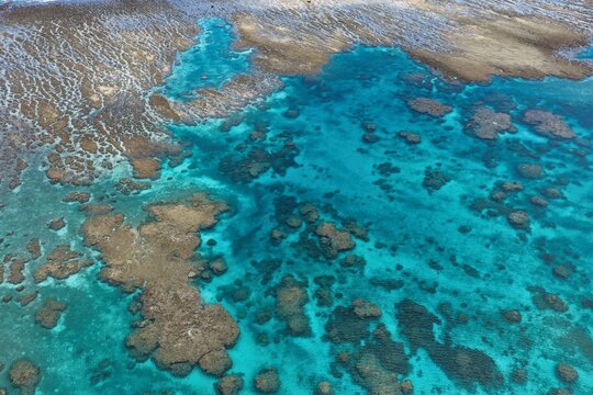 Aerial view of Shagira Bay featuring vibrant coral reef formations and clear turquoise waters in Miyakojima, Okinawa, Japan.